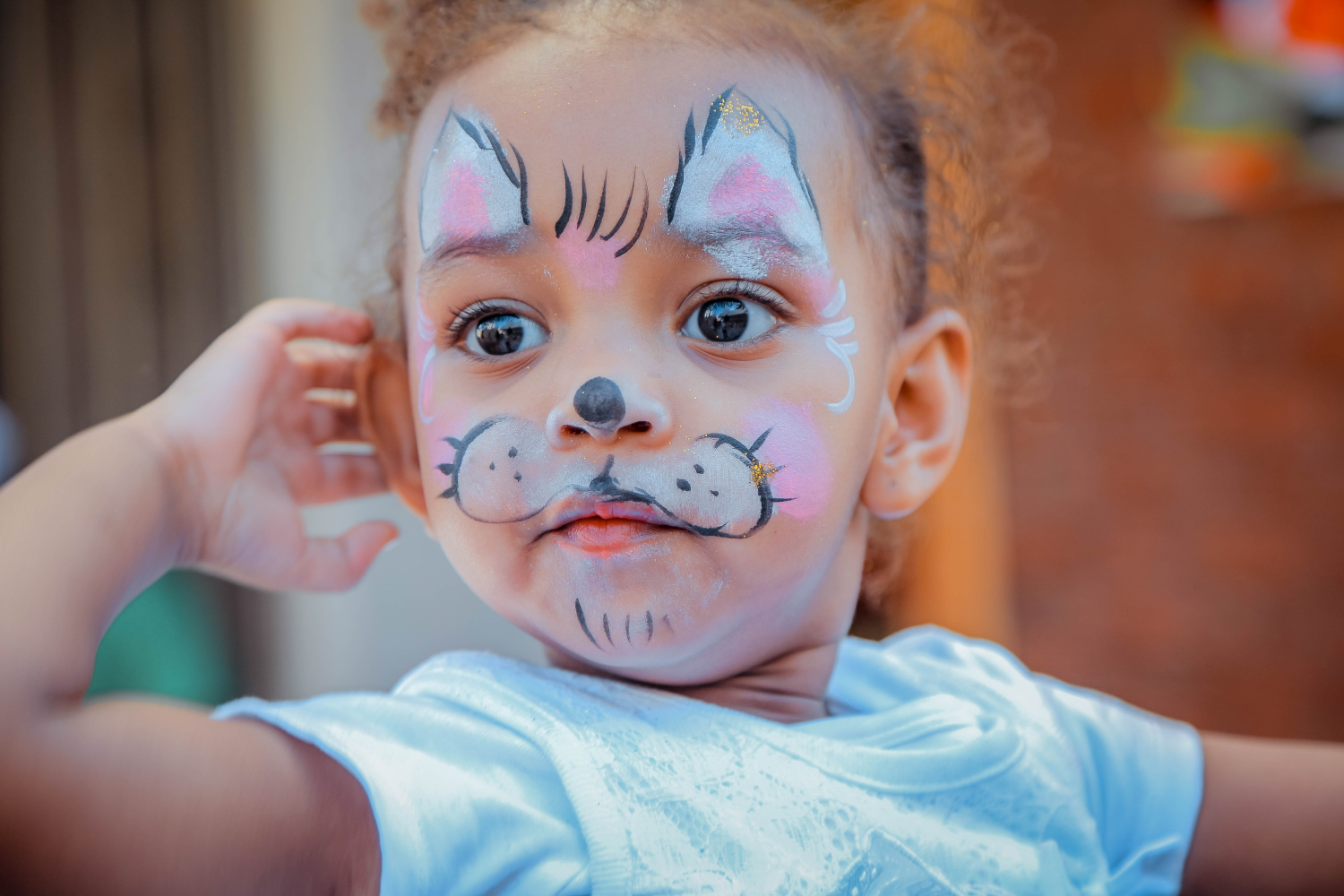 Girl with her face painted as a cat