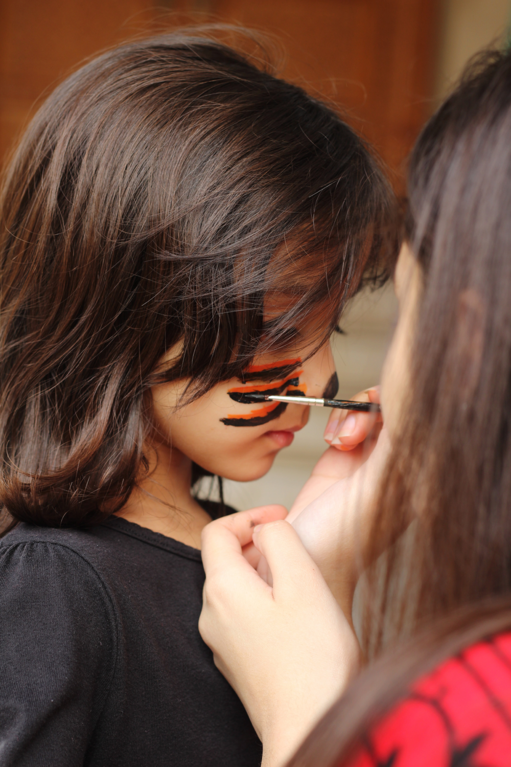 Girl with her face painted as a lion